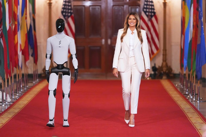 First lady Melania Trump, right, arrives, accompanied by a robot, left, to attend the “Fostering the Future Together” summit with other first spouses at the White House.
