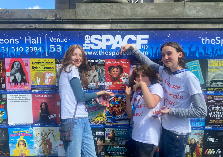 The author's children in front of a poster for her one-woman show in Edinburgh, Scotland, in 2023