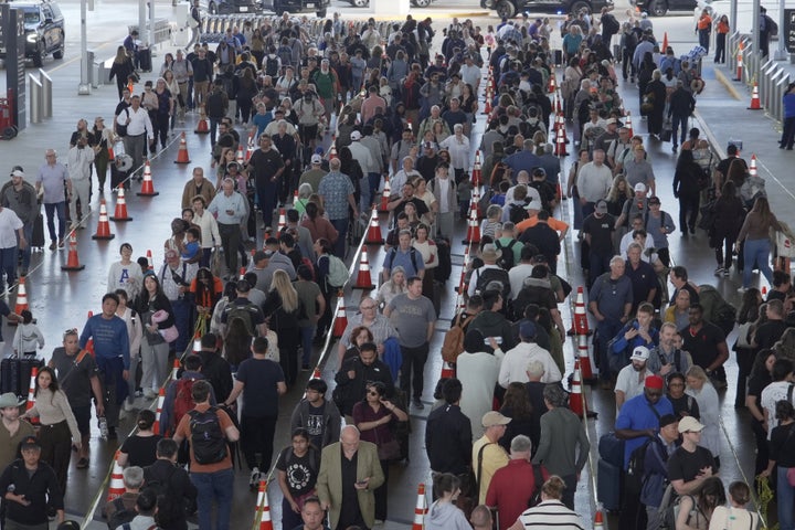 Travelers line up at a TSA checkpoint at George Bush Intercontinental Airport in Houston, Thursday, March 26, 2026. (AP Photo/Lekan Oyekanmi)