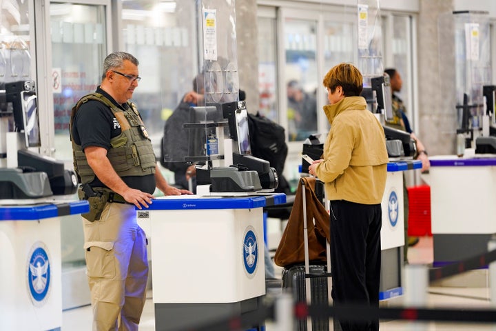 An ICE agent checks a person's ID at the security check point in Atlanta Hartsfield-Jackson International Airport on March 26, 2026 in Atlanta, Georgia. (Photo by Megan Varner/Getty Images)
