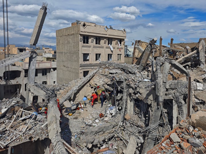 Rescue workers search for bodies in the rubble of a residential building following a hit in an airstrike in the early hours of March 27, 2026 in Tehran, Iran. (Photo by Majid Saeedi/Getty Images)
