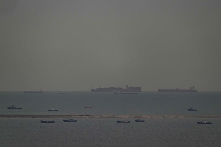 Fishing boats dot the sea as cargo ships, in the background, sail through the Arabian Gulf toward the Strait of Hormuz off the United Arab Emirates, Friday, March 27, 2026. (AP Photo)