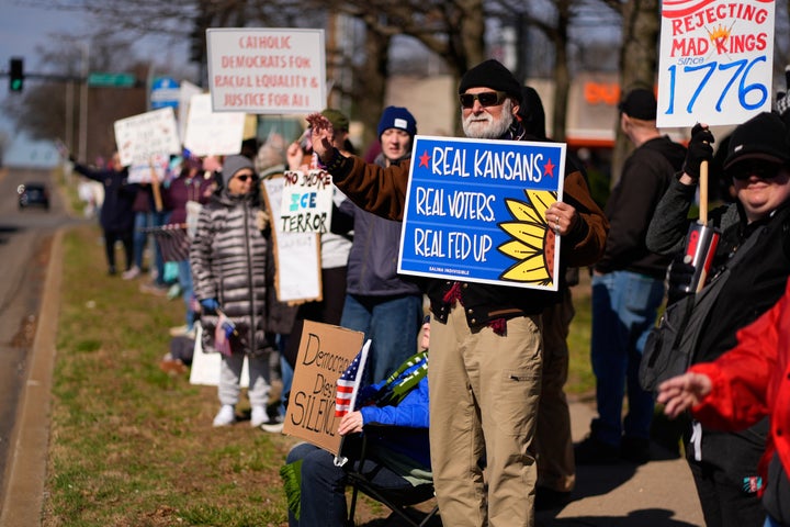 Demonstrators line the street during a No Kings protest in Overland Park, Kansas.