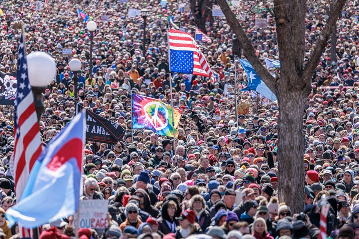 A person holds an inverted US flag as a large crowd gathers outside the Minnesota State Capitol during the "No Kings" national day of protest in Saint Paul, Minnesota, on March 28, 2026. 