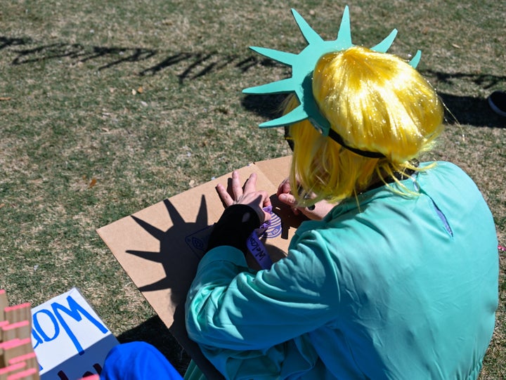 A demonstrator sits at the "No Kings" rally in Charlotte, North Carolina, where more than five thousand participants gathered.