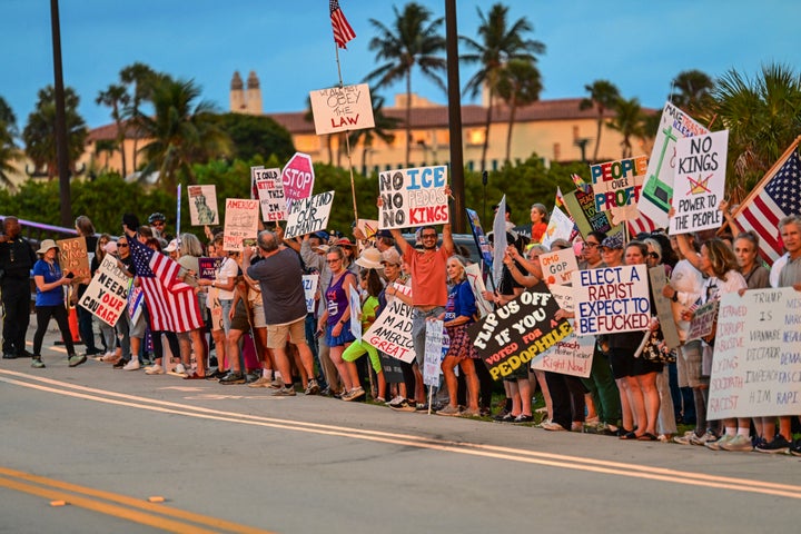 Protesters hold signs near US President Donald Trump's Mar-a-Lago resort during the "No Kings" national day of protest, in Palm Beach, Florida, on May 28, 2026. 