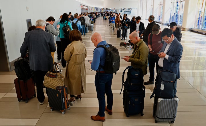 Passengers stand in the TSA pre check in line at New York City's LaGuardia Airport on March 26.