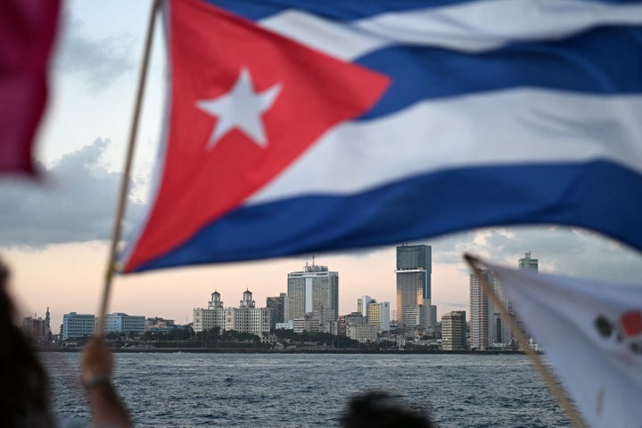 An activist waves a Cuban flag on board a vessel as it arrives from Mexico with humanitarian aid at the port of Havana on March 24, 2026. (Photo by YURI CORTEZ / AFP via Getty Images)
