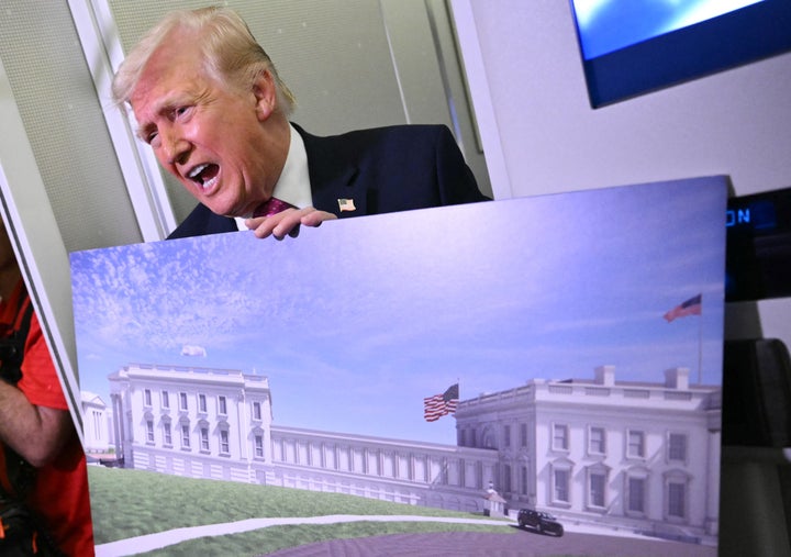 Donald Trump holds a rendering of the new East Wing aboard Air Force One on March 29, 2026. "The military is building a massive complex under the ballroom, and that's under construction, and we're doing very well, so we're ahead of schedule," Trump said. 