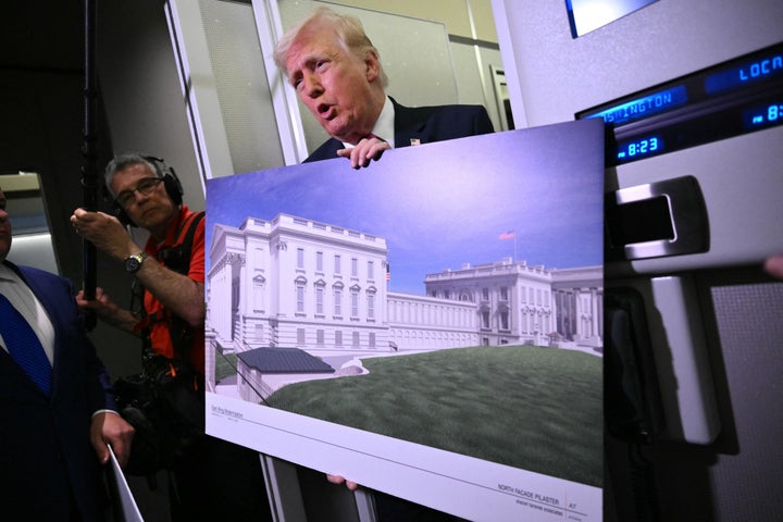 US President Donald Trump holds a rendering of the East Wing modernization as he speaks to reporters aboard Air Force One en route to Joint Base Andrews, Maryland, on March 29, 2026.
