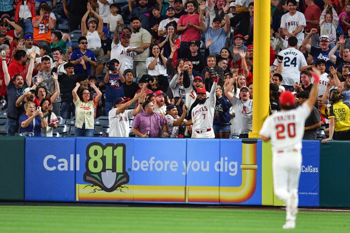Los Angeles Angels outfielder Jo Adell (7) falls into the stands after he robbed his third home run of the game in the 9th inning of a game between the Seattle Mariners and the Los Angeles Angels on Saturday at Angel Stadium.