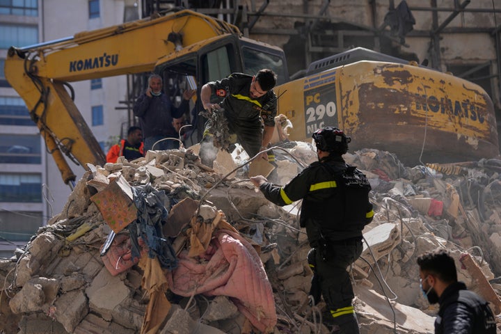 Lebanese civil defense workers search through rubble at the site of a building destroyed in an Israeli airstrike a day earlier in Beirut, Lebanon, Thursday, April 9, 2026. (AP Photo/Hussein Malla)