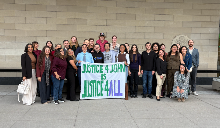 Jonathan Caravello surrounded by his students, colleagues and friends after a jury acquitted him of federal assault charges.