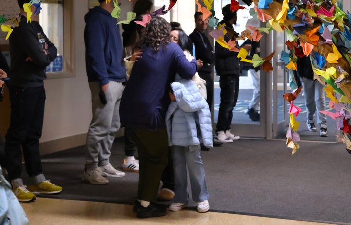 A student who attends Columbia Heights Public Schools hugs a teacher she hasn't seen since January as she walks into high school for the start of fourth quarter.