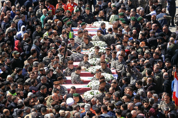 Mourners gather around the coffins of the members of Lebanon's State Security agency, who were killed by an Israeli strike, during their funeral in Sidon on April 11, 2026. (Photo by MAHMOUD ZAYYAT / AFP via Getty Images)