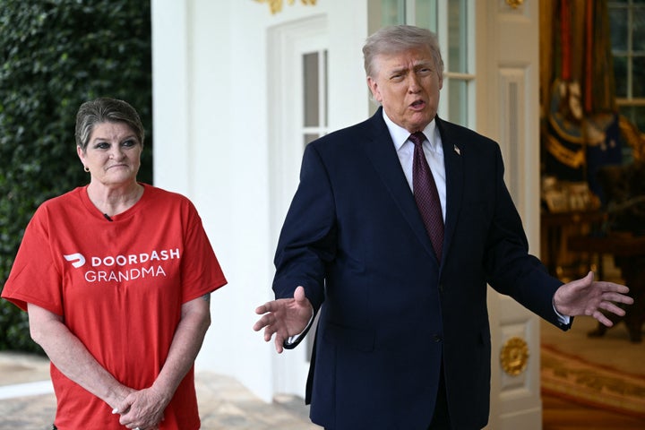 President Donald Trump speaks to reporters next to a DoorDash delivery worker outside the Oval Office at the White House, in Washington, D.C., on Monday.