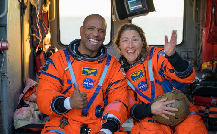 In a handout photo provided by NASA, astronauts Victor Glover and Christina Koch wave to the camera after being extracted from the Orion spacecraft after splashdown on Friday.