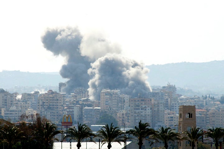 Smoke rises behind palm trees and a McDonald's "Golden Arches" logo from the site of an Israeli airstrike that targeted the Al-Hosh area near the coastal Lebanese city of Tyre on April 14, 2026. (Photo by Kawnat HAJU / AFP via Getty Images)