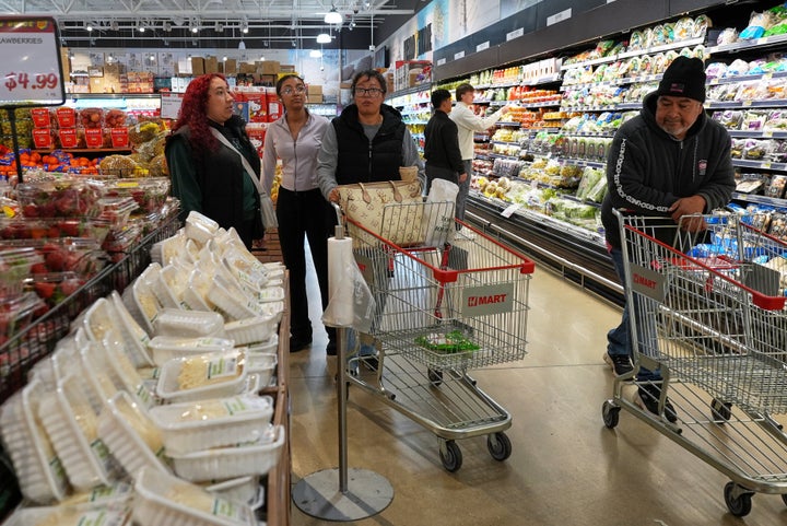 People shop at a grocery store, in Schaumburg, Ill., Thursday, April 2, 2026. (AP Photo/Nam Y. Huh)