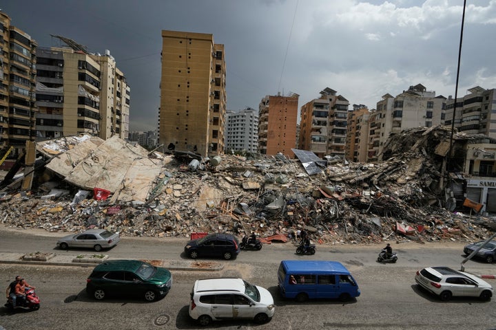 Residents drive past the rubble of destroyed buildings in Dahiyeh, Beirut's southern suburbs, Lebanon, on April 17, 2026, following a ceasefire between Israel and Hezbollah.