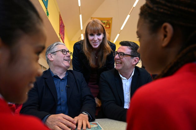 Britain's Prime Minister Keir Starmer, left, former deputy prime minister Angela Rayner and Manchester Mayor Andy Burnham meet with school children at a primary school in Ashton-under-Lyne, north-west England, Monday April 13, 2026. 