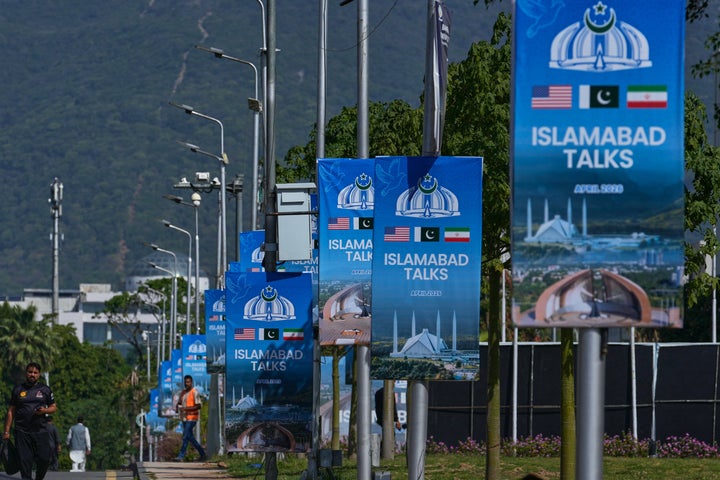 Workers walk past billboards near the Serena Hotel ahead of the second round of negotiations between the U.S. and Iran, in Islamabad, Pakistan, on April 20, 2026. With tensions flaring and the ceasefire due to expire midweek, Pakistan has intensified diplomatic contacts with both Washington and Tehran over the past 24 hours with the goal of resuming the talks on Tuesday as planned, according to two Pakistani officials.