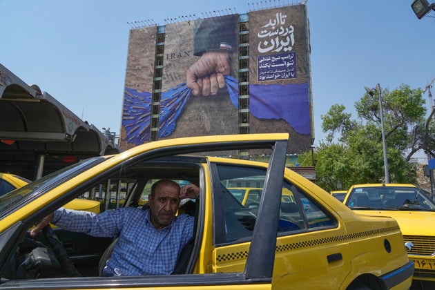 A billboard in northern Tehran, depicting a uniformed fist clutching the Strait of Hormuz, reads in Farsi: 