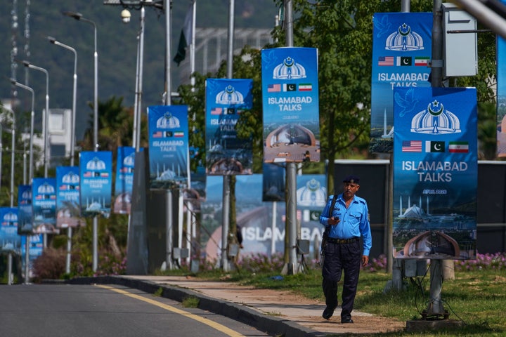 A police officer walks past billboards near the Serena Hotel ahead of the second round of negotiations between the U.S. and Iran, in Islamabad, Pakistan, on April 21, 2026. Pakistan pressed ahead with the groundwork for a second round of talks between Iran and the United States in Islamabad as a fragile ceasefire hung in the balance.