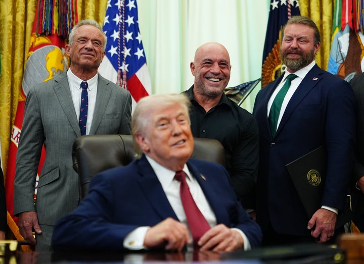 Rogan, center, was at the Oval Office on Saturday when Trump signed the executive order.