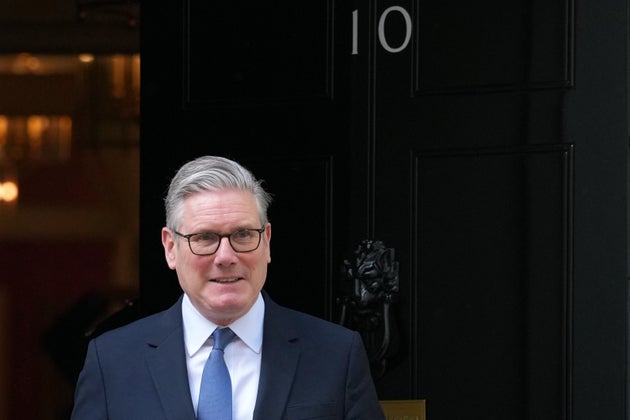 Britain's Prime Minister Keir Starmer steps out of the 10 Downing Street door to welcome Secretary General of the Council of Europe, Alain Berset, in London, Wednesday, April 22, 2026.