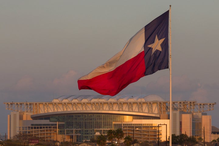 A Texas state flag backdropped by the NRG Stadium in Houston, one of the venues of the 2026 FIFA World Cup.