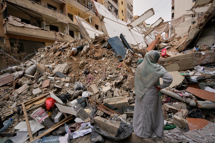 A woman stands by the rubble of a destroyed building, following a ceasefire between Hezbollah and Israel, in Dahiyeh, Beirut's southern suburbs, Lebanon, on April 20, 2026.