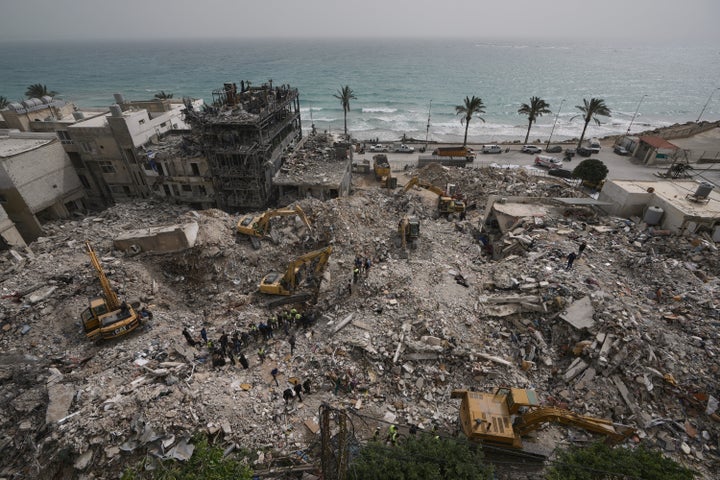 Excavators remove rubble from destroyed buildings that were hit by Israeli airstrikes on Thursday, as rescuers search for victims in the city of Tyre, southern Lebanon, on April 18, 2026.
