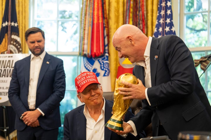 FIFA president Gianni Infantino presents President Donald Trump with the FIFA World Cup Trophy as he speaks to journalists at the White House in August 2025.