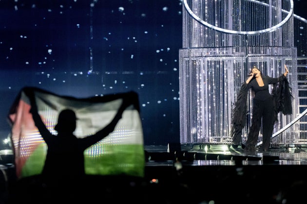 A demonstrator holding up a Palestinian flag during the Israeli act's performance at the 2025 Eurovision Song Contest