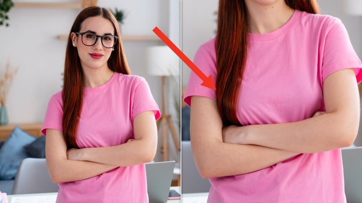 Professional young woman with glasses standing arms crossed in a bright home office, exuding confidence and competence