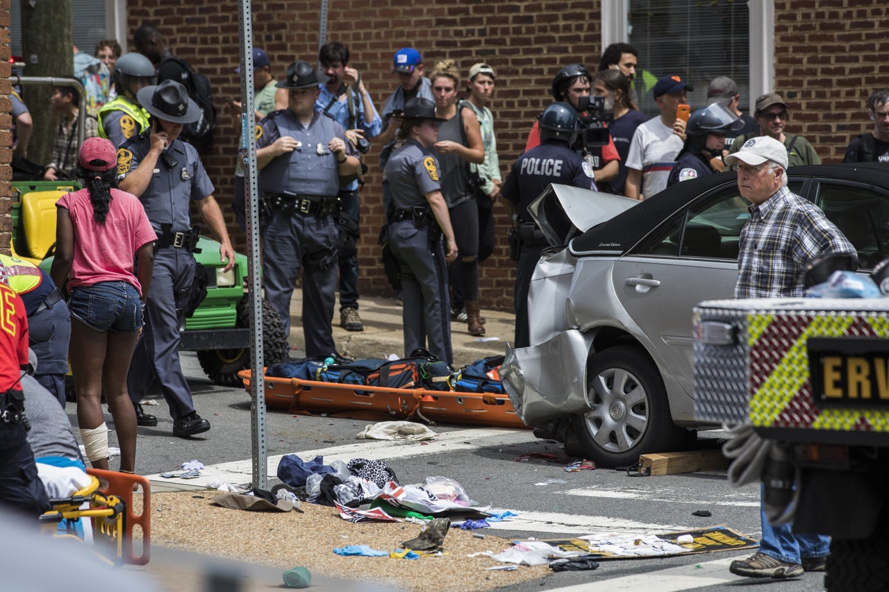 Police, medical personnel and protesters attend to injured people after a car rammed into a crowd of anti-white-supremacy marchers in Charlottesville, Viriginia, on Aug. 12, 2017. 