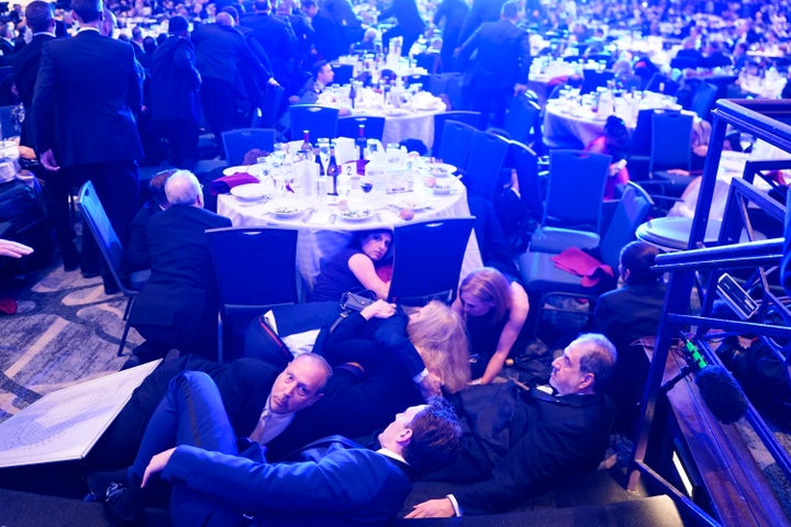 Attendees hide under tables after an incident at the annual White House Correspondents' Association Dinner on April 25.