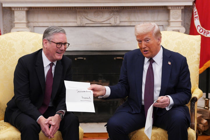 British Prime Minister Keir Starmer, left, hands an invitation from King Charles III to President Donald Trump at the White House, on Feb. 27, 2025, in Washington.
