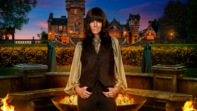 Claudia Winkleman posing in front of the iconic Traitors castle