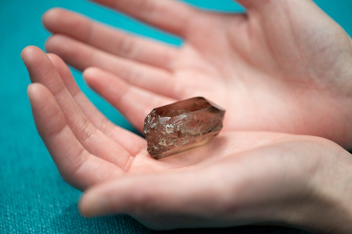 ジャケット写真でも使用された煙水晶を手のひらにのせて