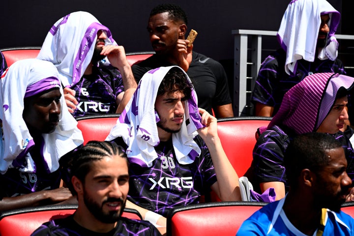 Hazim Abbas of Al Ain, center, protects himself from the sun with other players before the Club World Cup football match between Wydad AC and Al Ain FC in Washington in June 2025.
