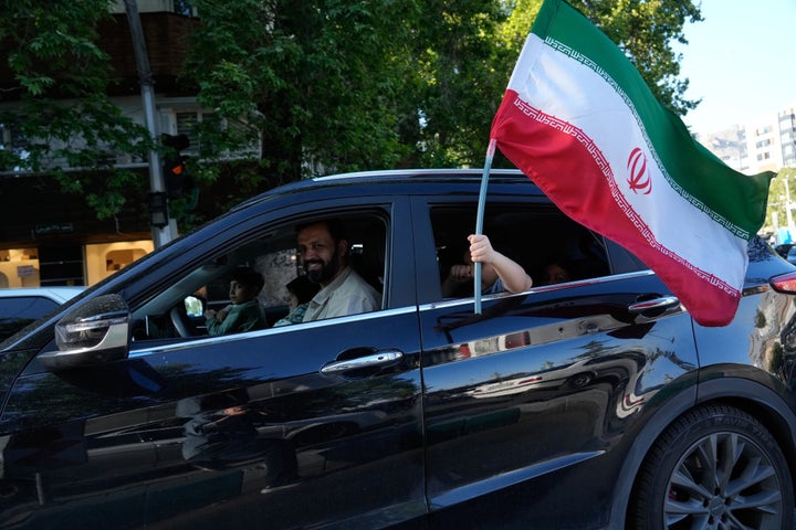 A child holds an Iranian flag through the window of a vehicle in northern Tehran, Iran, Friday, May 1, 2026. (AP Photo/Vahid Salemi)