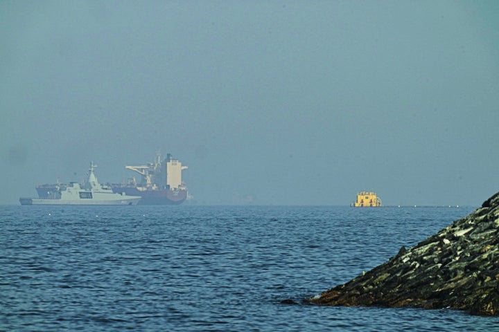 An Emirati patrol boat, left, stands near a tanker anchored in the Gulf of Oman near the Strait of Hormuz, as seen from a coastal road near Khor Fakkan, United Arab Emirates, Friday, May 1, 2026. (AP Photo/Fatima Shbair)