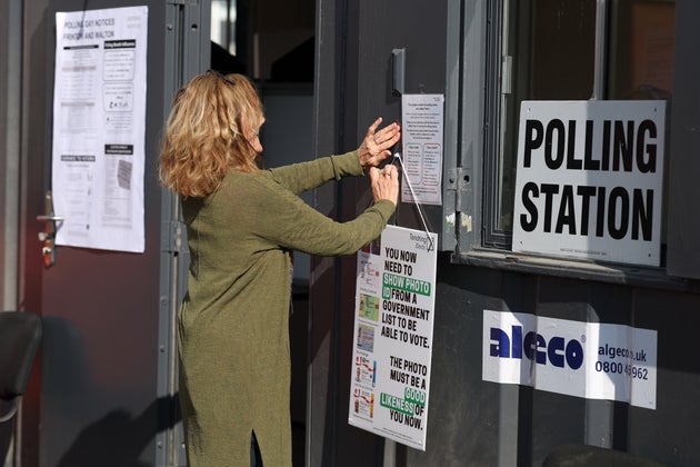 A worker prepares signs at a polling station in Walton on the Naze, England, Thursday, May 7, 2026 as polls open in UK local elections.