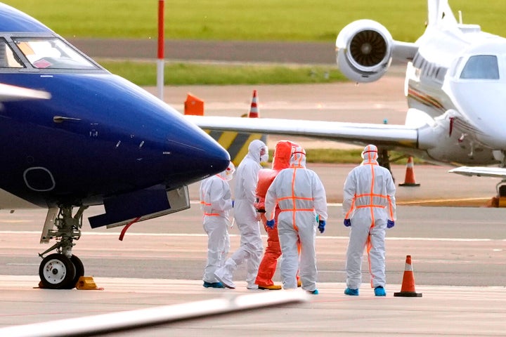Medics escort a patient, second left, evacuated from the MV Hondius cruise ship with suspected hantavirus infection, to an ambulance after being flown to Schiphol airport, Amsterdam, Netherlands, Wednesday, May 6, 2026. (AP Photo/Peter Dejong)