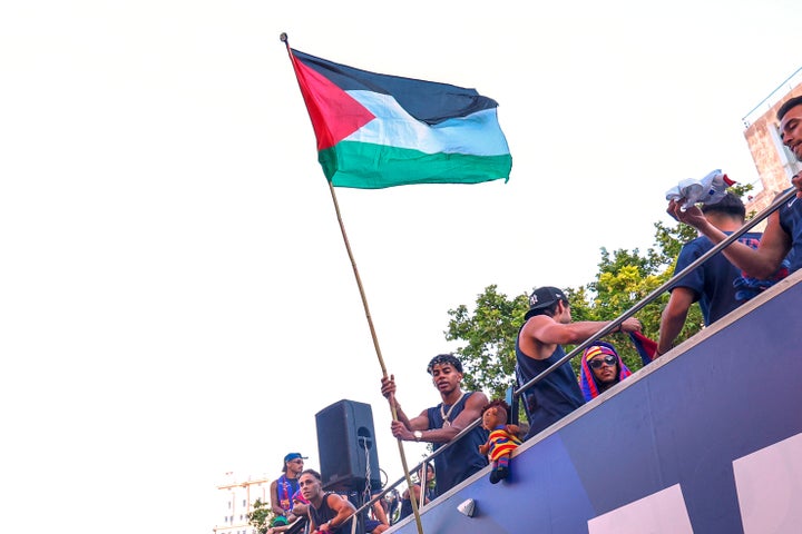 FC Barcelona player Lamine Yamal holds a Palestinian flag as he celebrates with his team atop a bus after winning the Spanish La Liga title in Barcelona.