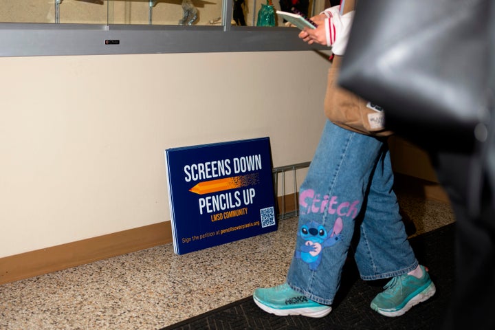 Signs reading, "Screens down, pencils up," are seen a school board meeting at the Lower Merion School District Administration Building on Monday, May 11, 2026, in Ardmore, Pennsylvania.