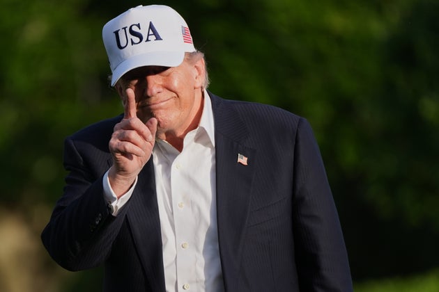 Donald Trump gestures to reporters as he walks across the South Lawn of the White House.