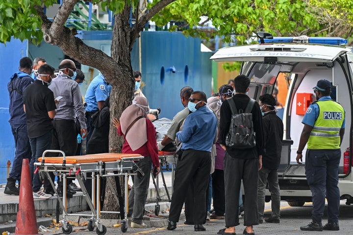 Red Crescent emergency response teams and police personnel transferred the bodies of Italian tourists from a police speedboat to an ambulance in Male' on Tuesday.
